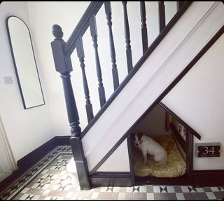 Dog house built into stairwell with patterned tiled floorng