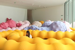 Enredos: Eva Fàbregas: person amid colourful inflatable sculptures
