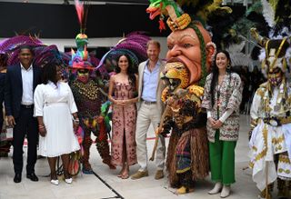 Meghan Markle and Price Harry stand side by side at a dance performance where meghan markle wears a patterned johanna ortiz dress