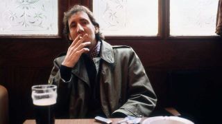 Pete Townshend smoking a cigarette in a pub