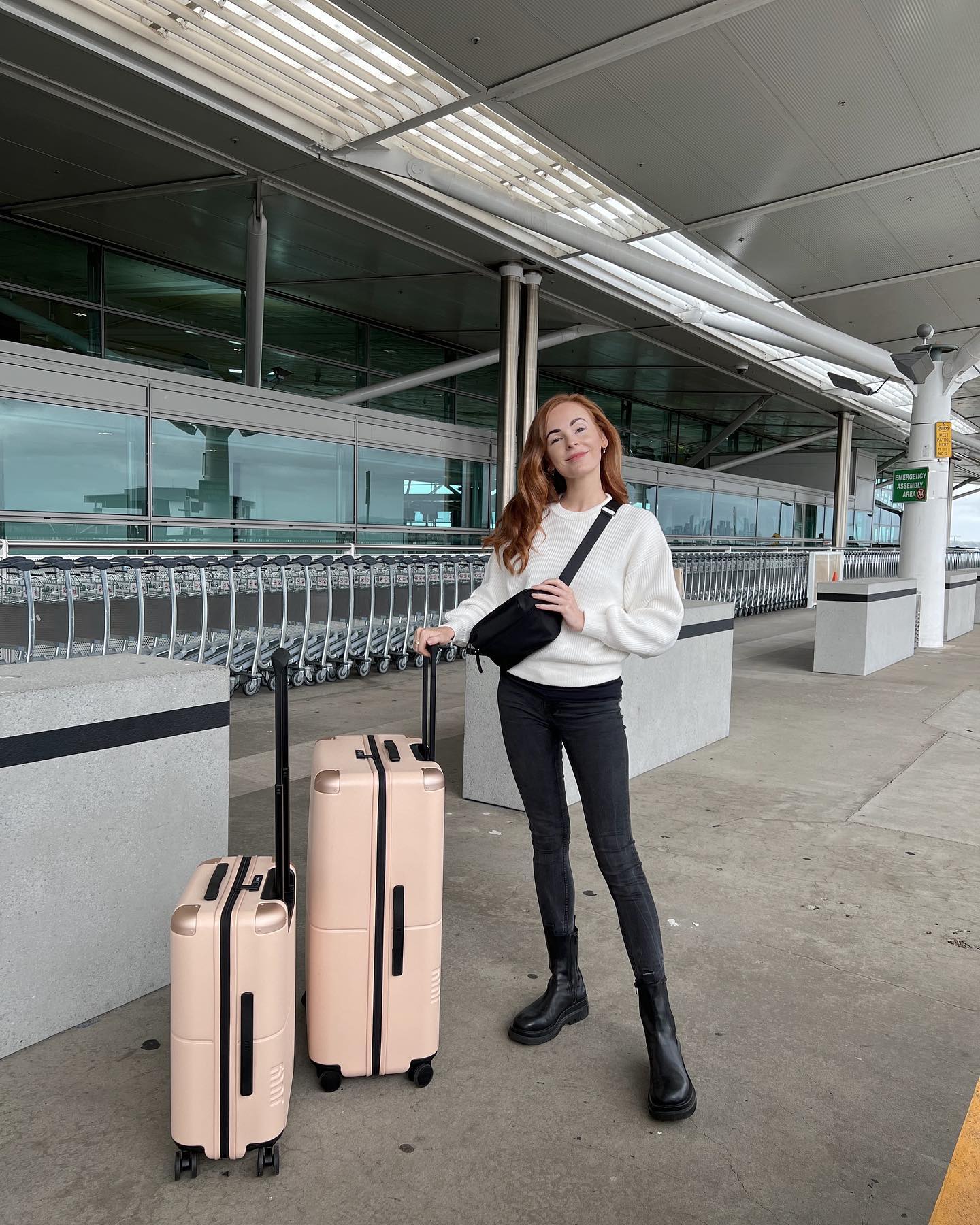 Brooke Saward travel influencer at the airport with her pink luggage