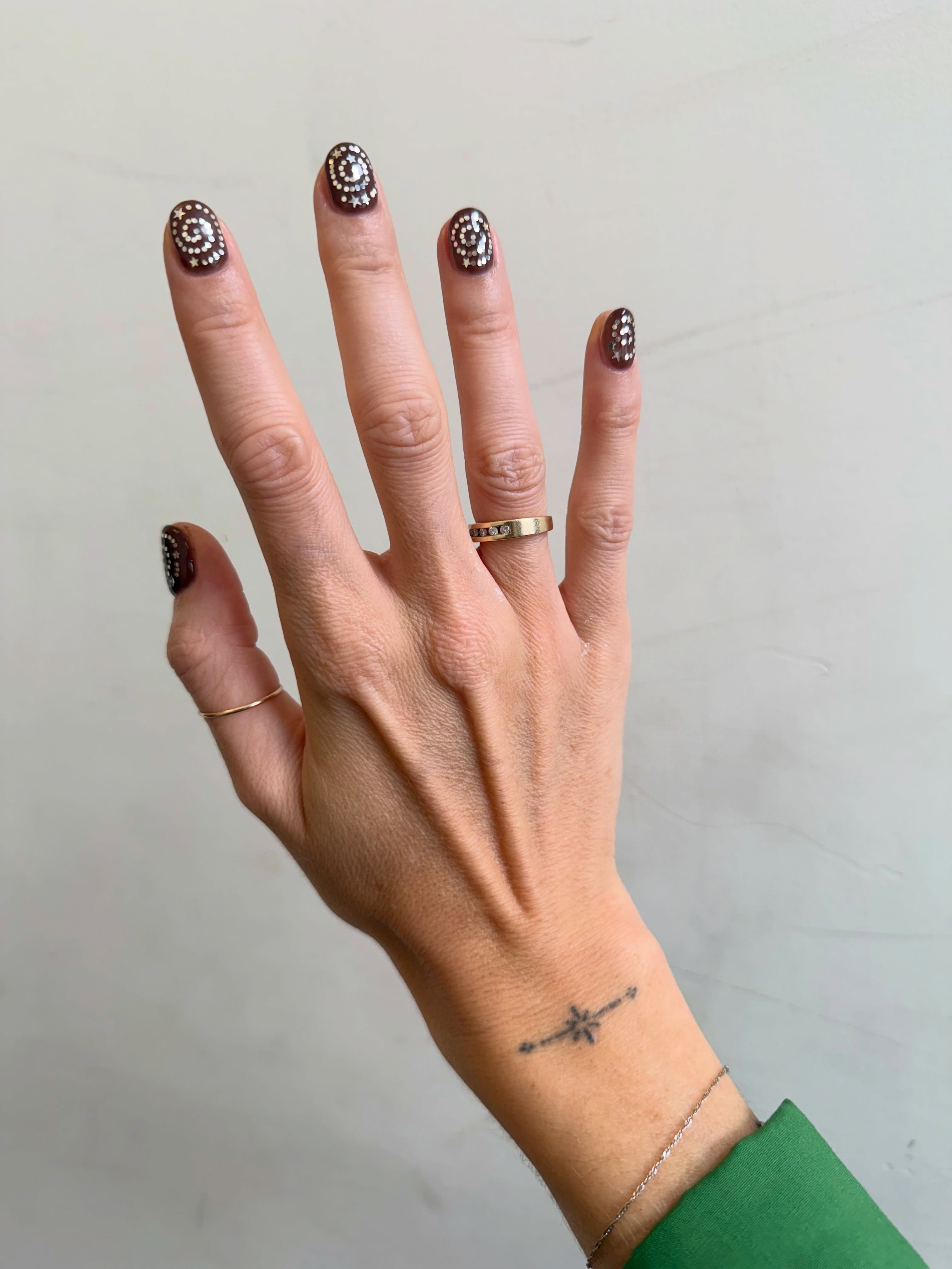 Short brown nails decorated with metallic silver swirly