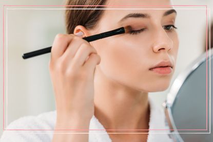 A close-up shot of a woman applying eyeshadow, to show How do you apply eyeshadow to hooded eyes