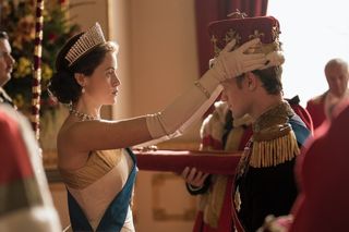 Elizabeth (Claire Foy) places a crown on Philip’s (Matt Smith) head.