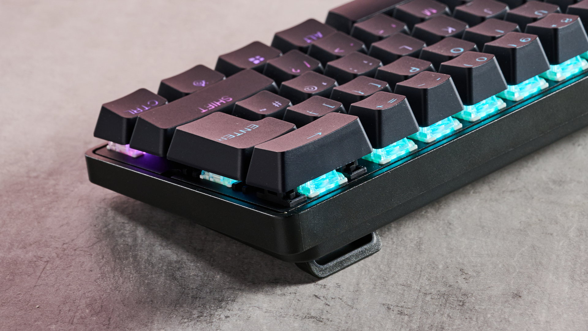 Close-up of switches underneath keys with RGB lighting on SteelSeries Apex Pro Mini on desk