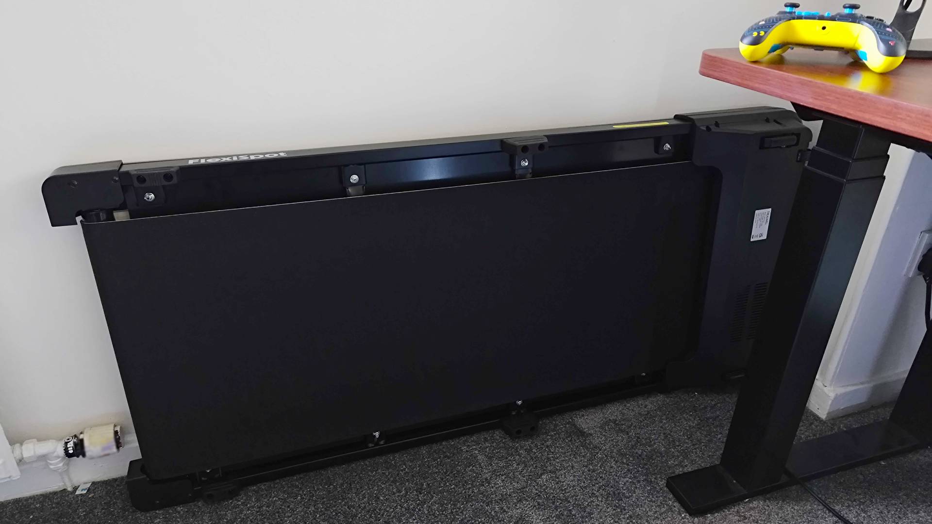Flexispot Under Desk Treadmill against wall on side next to E7 Plus desk.