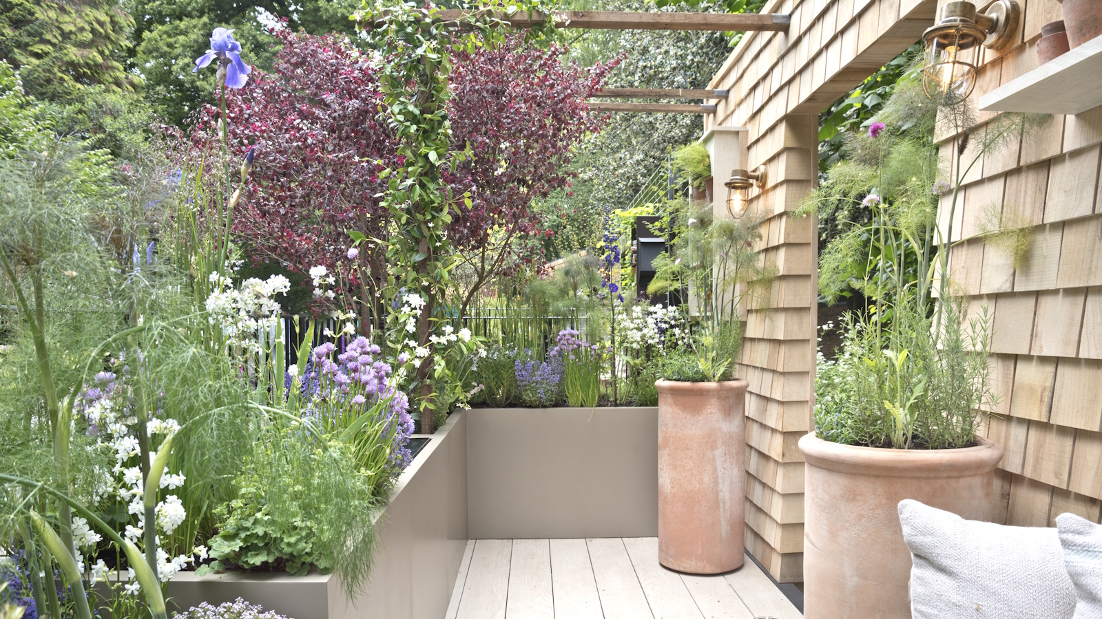 RHS Chelsea Flower Show 2023, with a terrace garden showcasing pots and planters full of colorful flowers, perennials and shrubs