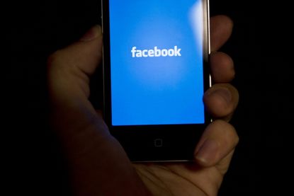 Facebook logo displayed on an iPhone.