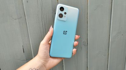 OnePlus Nord CE 2 Lite review: blue phone held up against blue wooden wall