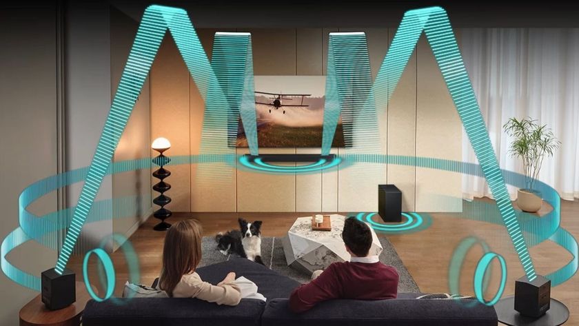 A render of a couple watching TV in a living room with green beams used to illustrate the sound coming from the soundbar and various other speakers.