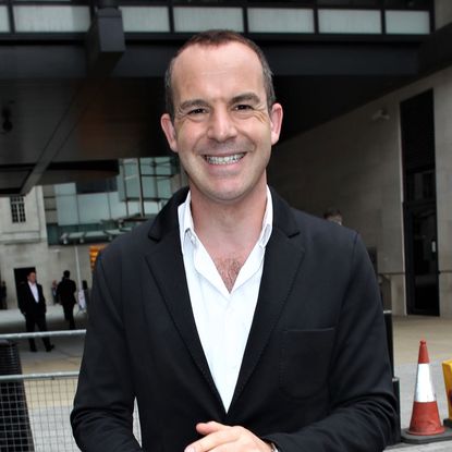 martin lewis smiling under wooden ceiling room