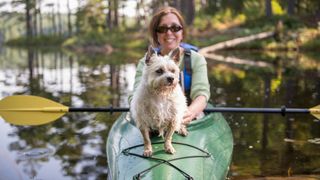 Woman kayaking with her Cairn Terrier dog
