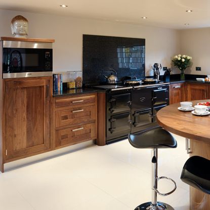 kitchen with wooden round table and wooden drawers