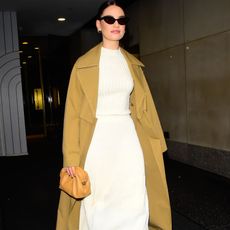 Lily James wearing a cream co-ord and trench coat GettyImages-1866989065