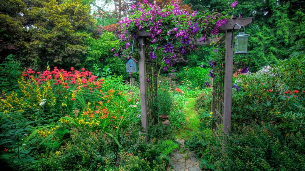 garden arbor along pathway and garden of colorful plants 