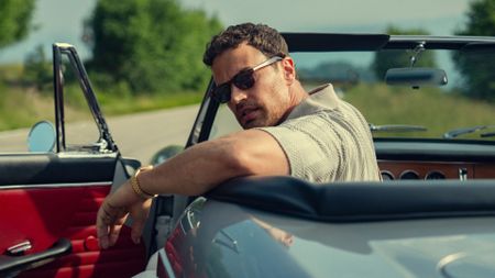 Theo James looks over his shoulder in a convertible