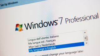 A close-up photo of a monitor showing a drop-down menu below the Windows 7 Professional logo