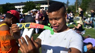 Asha Moore uses solar eclipse glasses and her iphone to show a friend from Canada on the phone the view of the partial solar eclipse from Beckman Lawn at Caltech in Pasadena, California on August 21, 2017.