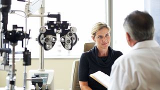 Can menopause cause dry eyes? - picture of woman at the eye doctors listening to optometrist