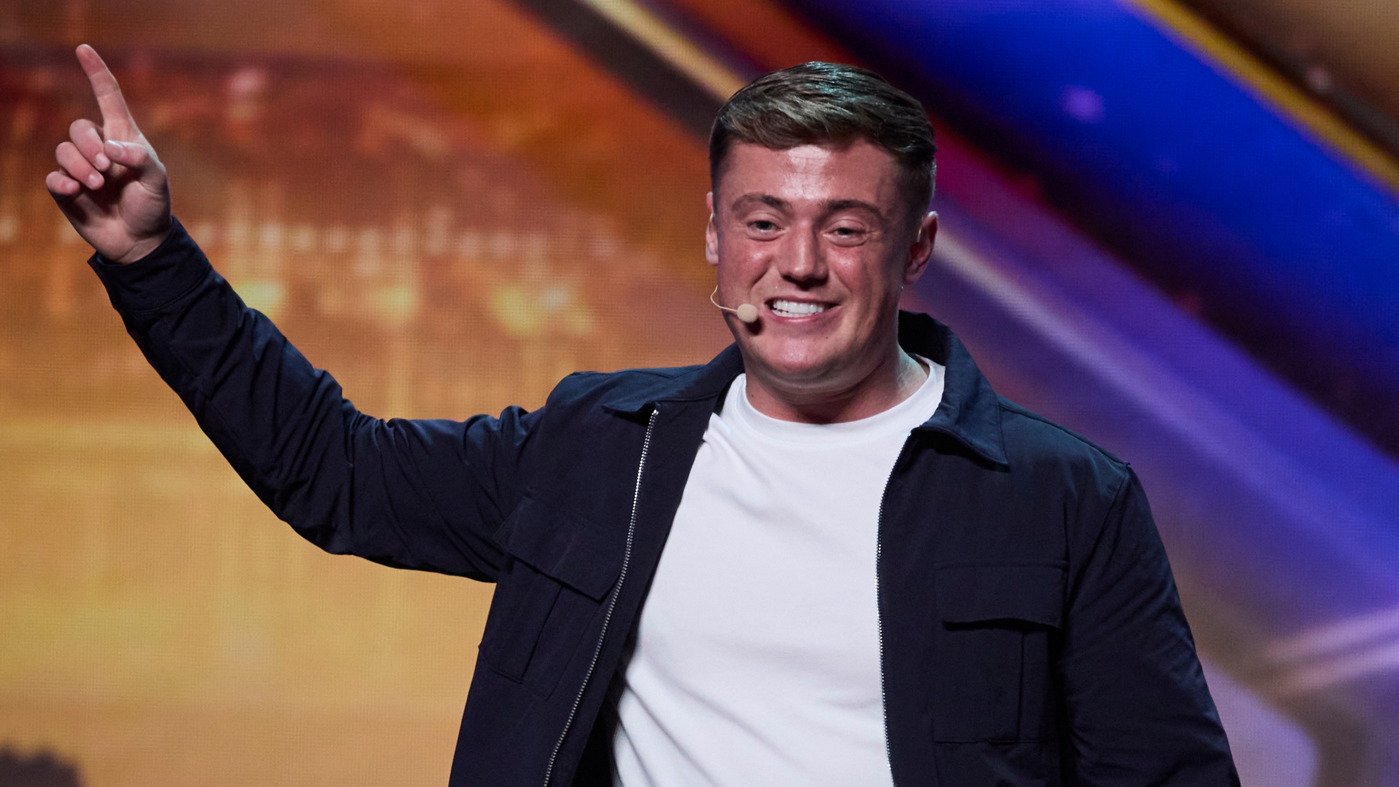 Harry Moulding on stage for BGT 2024 in a white t-shirt and a black jacket