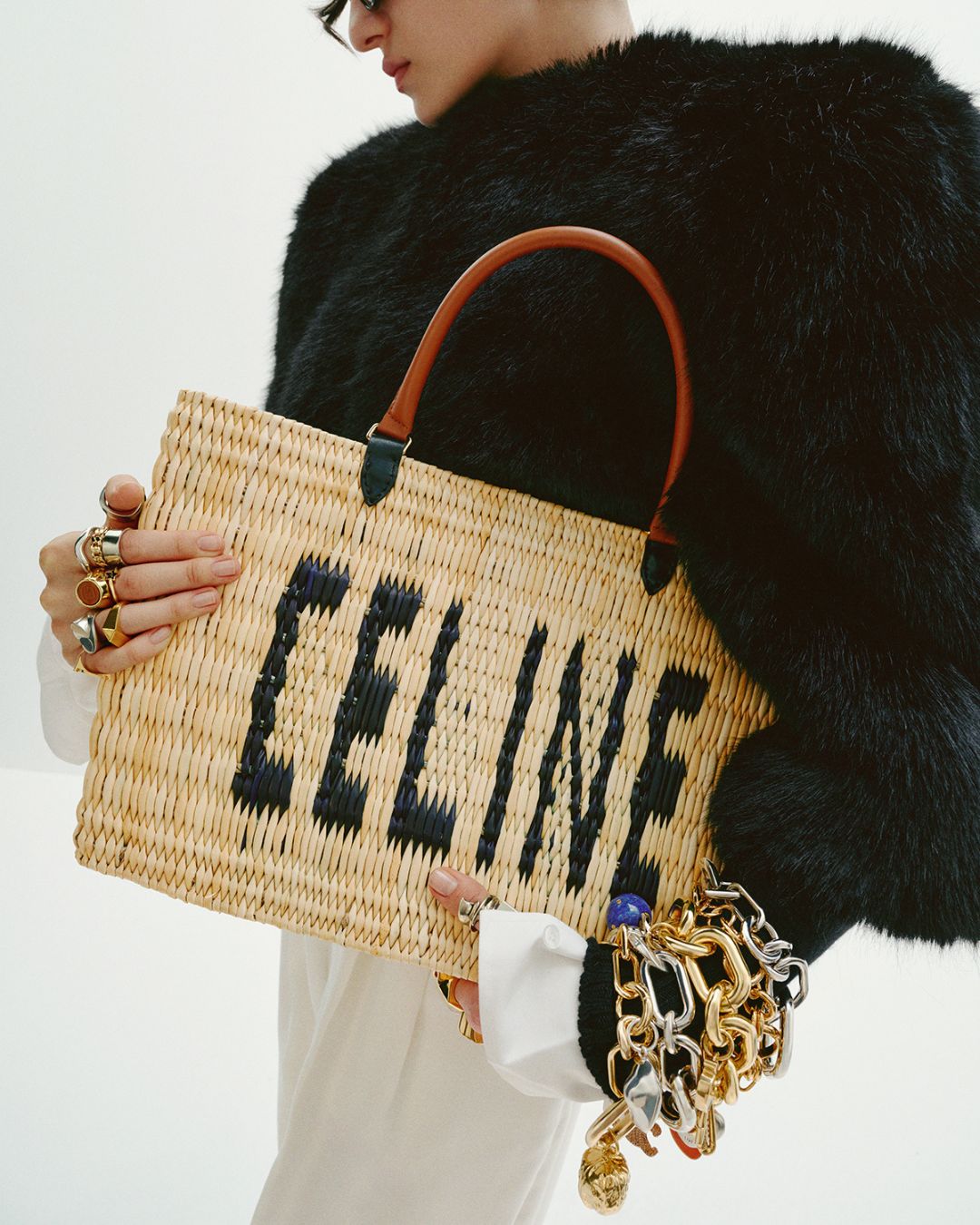 a model carries a celine straw bag