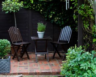 red brick patio with black table and chairs