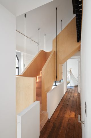 converted warehouse with pine staircase and white walls