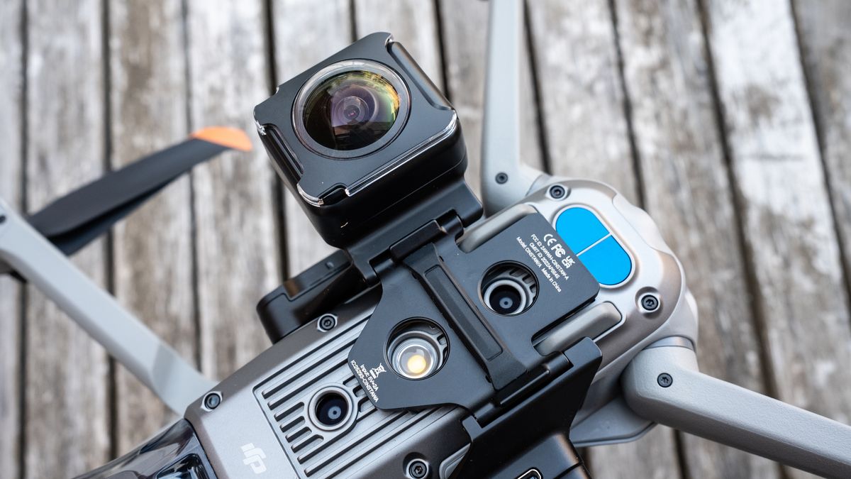 A DJI drone on a wooden table connected to the Insta360 Sphere 360 camera