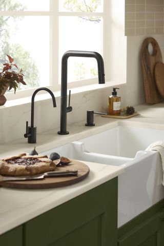 A black faucet and white farmhouse sink