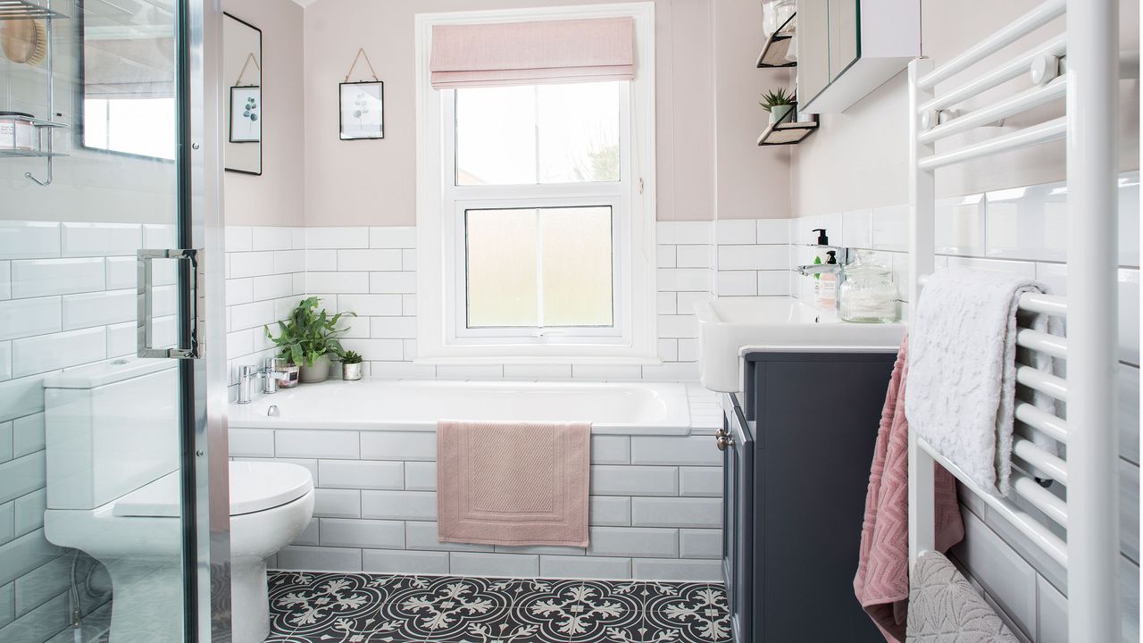 White and pink bathroom with victorian tiled flooring and large white metro tiles on wall