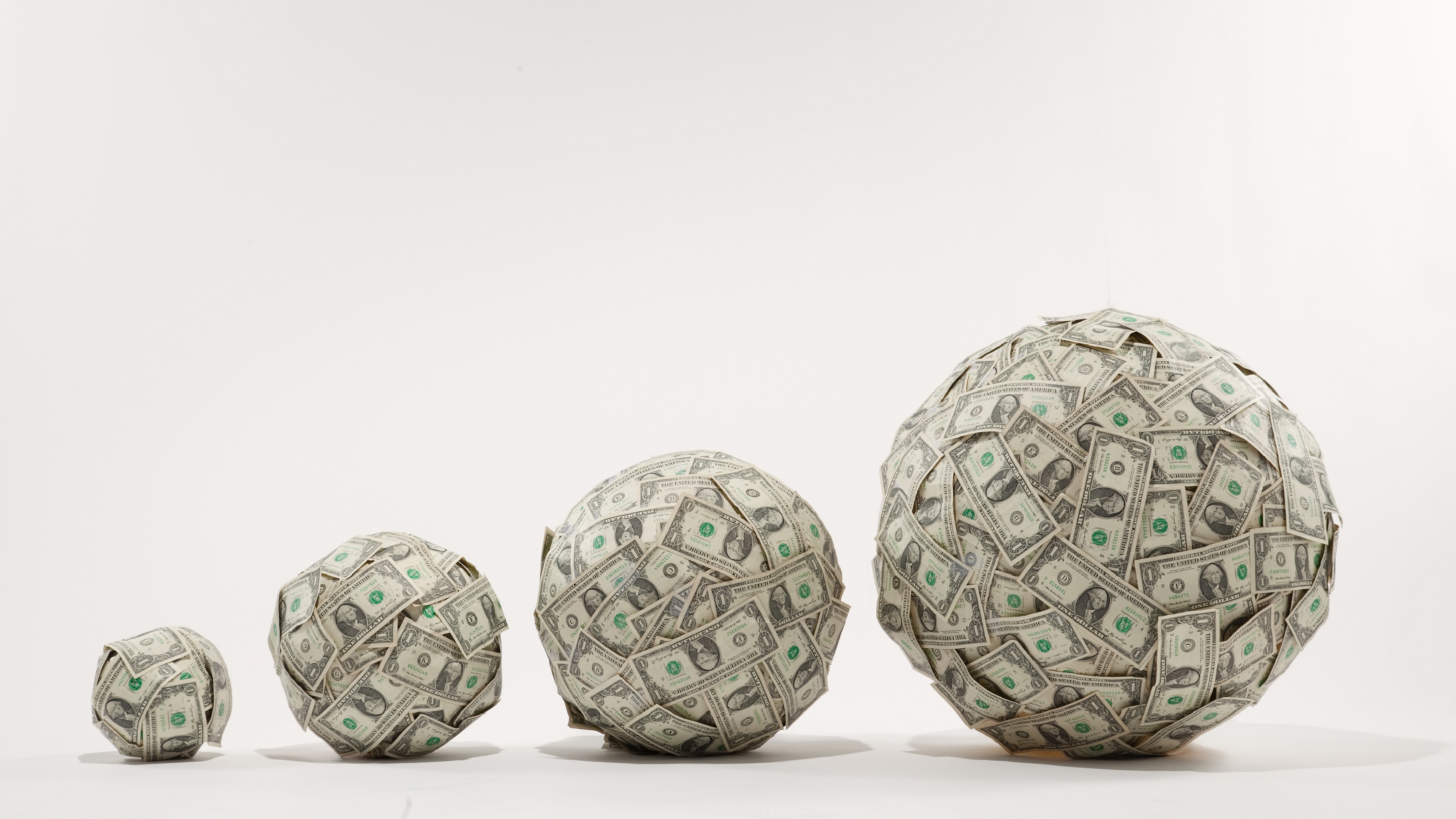 Four balls of money, each bigger than the one next to it.