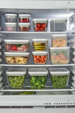 food in storage containers stacked in fridge