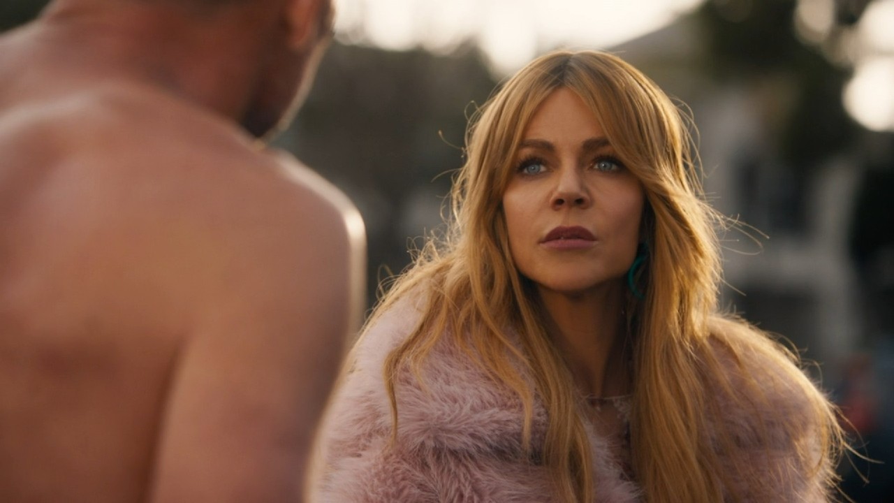 Kaitlin Olson talking to a man while looking up in High Potential.