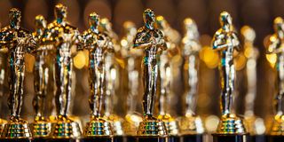Multiple Oscar statues sitting on a table
