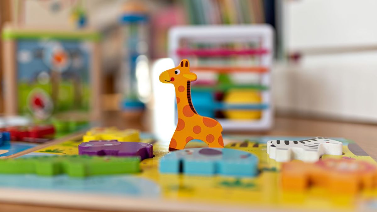 Colourful, wooden children&#039;s toys in the shape of animals on the floor of a nursery