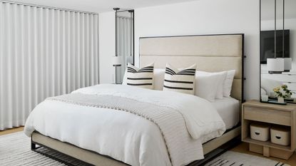 White bedroom space with striped cushions and modern nightstands