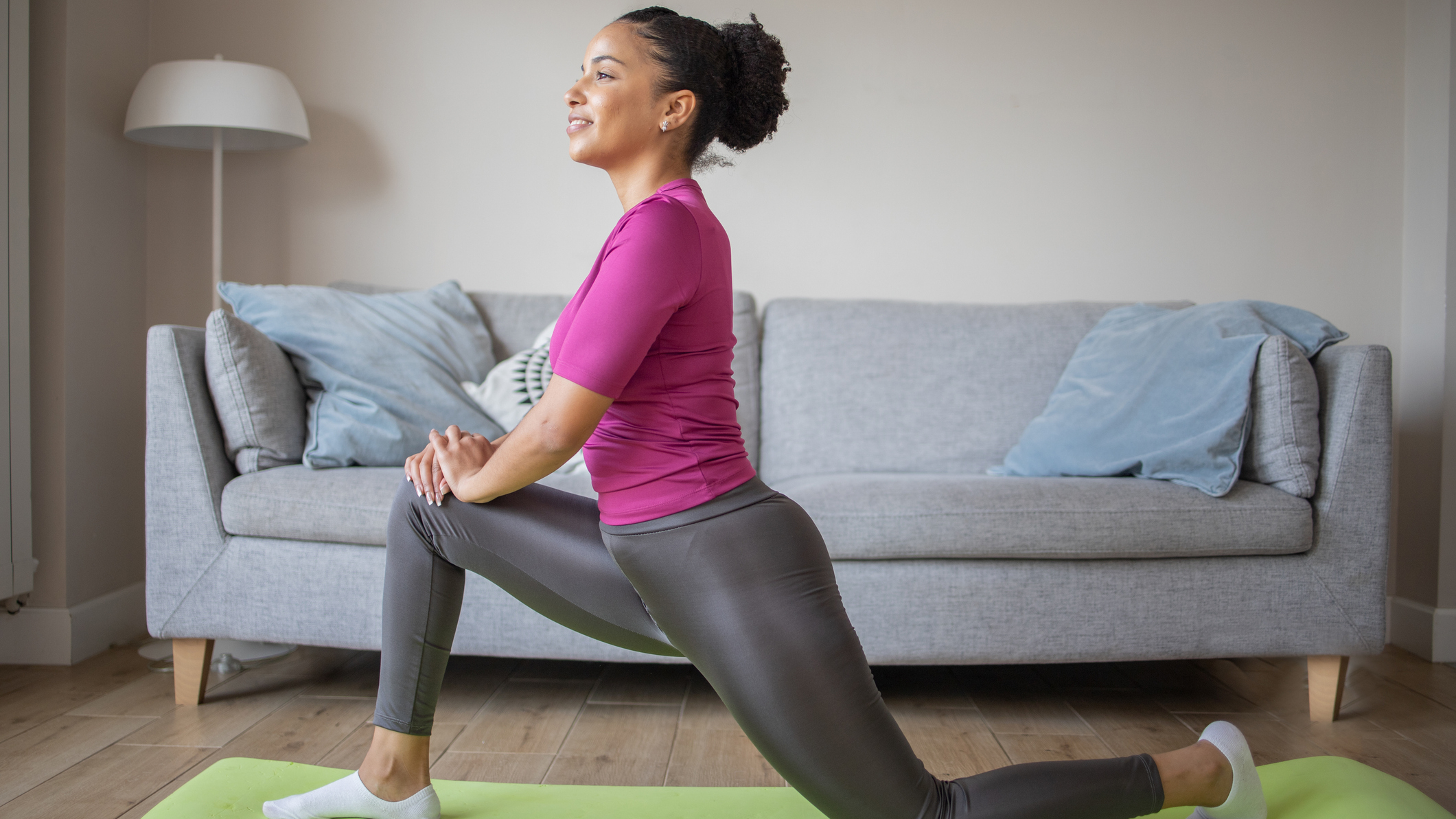 Woman stretching in front of couch