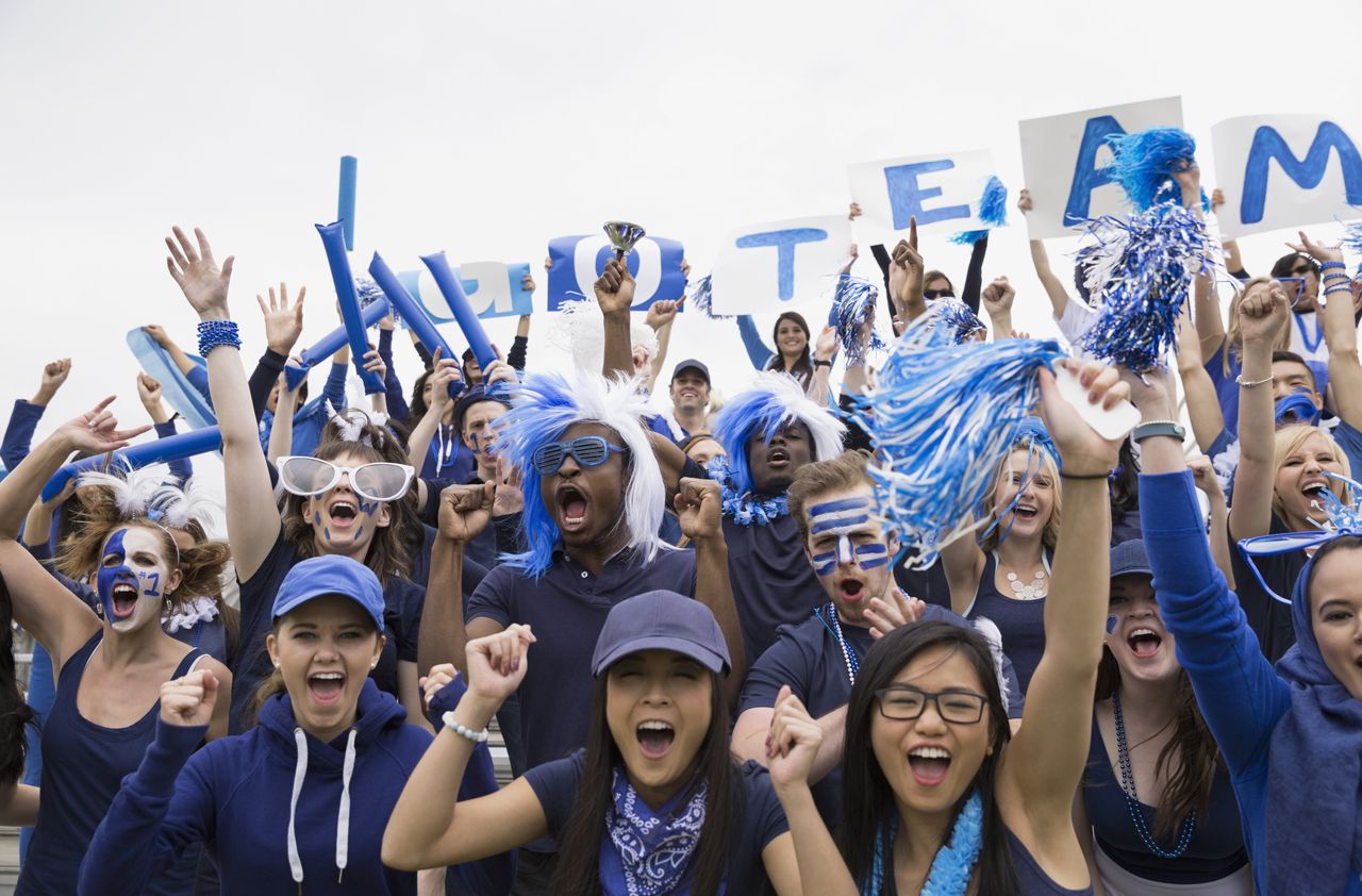 Portrait enthusiastic crowd in blue cheering sports event