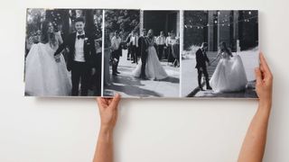 A pair of hands opening a photo book on a table