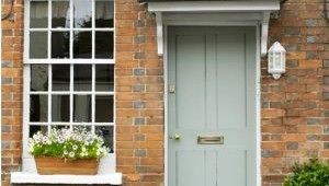 brick wall with white window and grey door