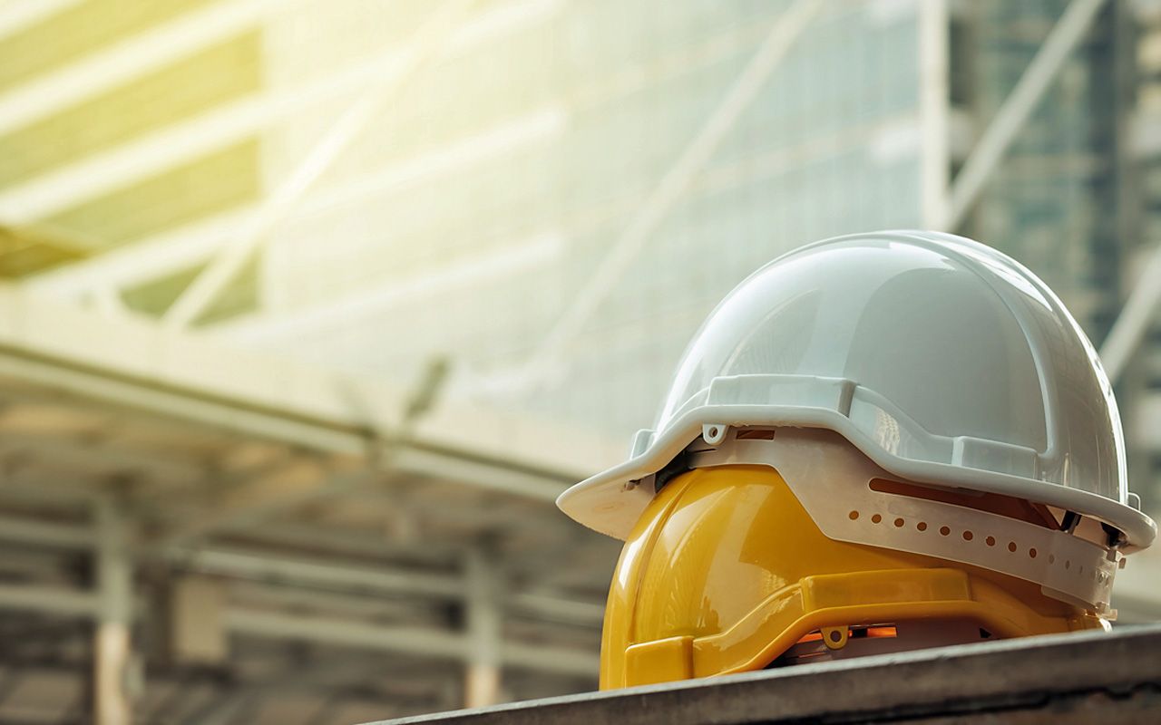 white, yellow hard safety helmet hat for safety project of workman as engineer or worker, on concrete floor on city