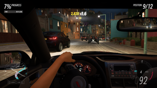 Forza Horizon 5 - a car interior in first person while a player holds the steering wheel in one hand racing on a brick road at night