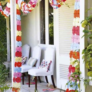 house with garlands on white walls and white chairs