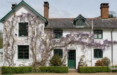 whitewashed part-Victorian part-Georgian home with wisteria