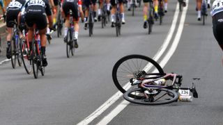 A road bike lays in the road after a crash