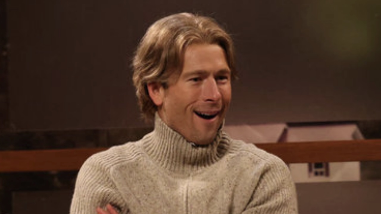 Glen Powell in SNL Norwegian movie set sketch smiling.