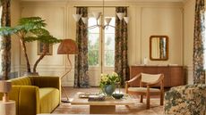 Colorful living room with yellow velvet sofa, wavy floor lamp, candelabra light and coffee table