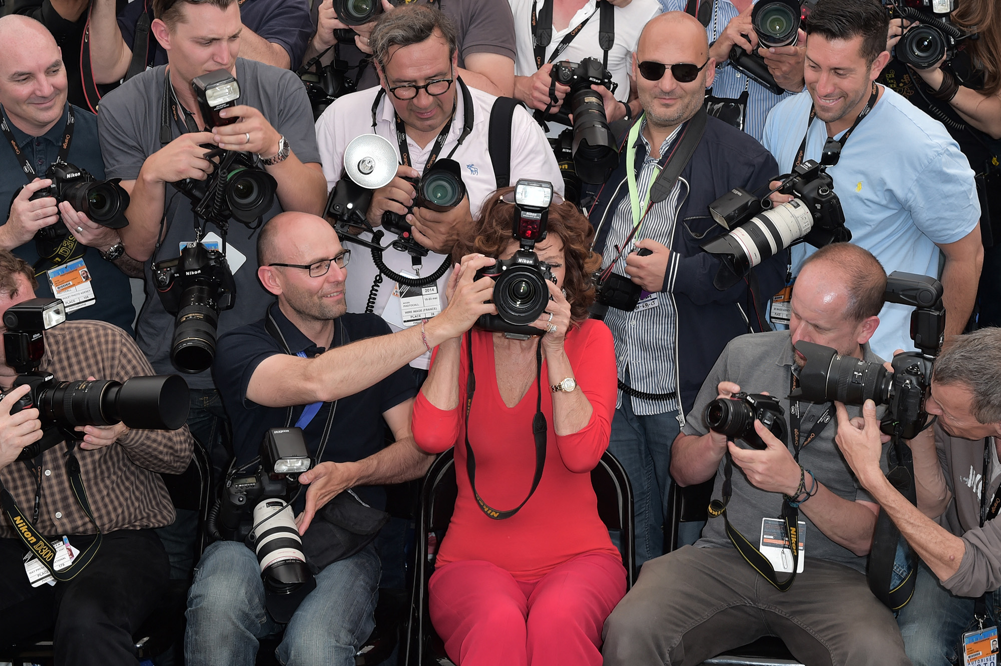 Italian actress Sophia Loren (center) holds a professional camera as she sits among photographers during a photocall for "Voce Umana" at the 67th edition of the Cannes Film Festival in Cannes, southern France, on May 21, 2014.