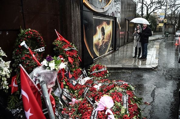 Mourners visit a memorial to the victims of the Reina massacre.