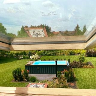 Attic room view of above ground pool in the middle of the garden